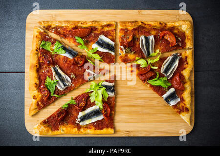 Pizza Marinara garniert mit Sardellen und Petersilie Stockfoto