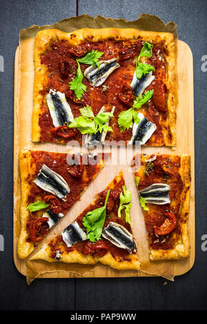 Pizza Marinara garniert mit Sardellen und Petersilie Stockfoto