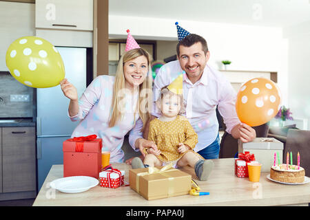 Eine Familie mit einem Kuchen gratuliert ein glückliches Kind an seinem Geburtstag Stockfoto