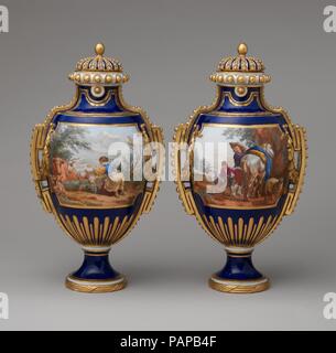 Vase mit Deckel (Vase à panneaux à Perles) (einer der beiden). Kultur: Französisch, Sèvres. Dekorateur: Dekoration Kränze zugeschrieben, Jean-Baptiste Tandart (Französisch, aktive 1754-1800); Pastorale Szenen zugeschrieben, Charles Nicolas Dodin (Französisch, Versailles 1734-1803 Sèvres). Abmessungen: Höhe: 13 cm. (33,3 cm). Manufaktur: Manufaktur Sèvres (Französisch, 1740). Datum: Ca. 1766. Die französischen Namen für diese Vasen (siehe auch 58.75. 84a-c) "à Panneaux' und 'à Perles" beziehen sich auf den Getäfelten behält sich vor, hier mit gemalten pastoralen Szenen nach der Kompositionen des niederländischen Malers Nicholaes Berchem, ein Stockfoto