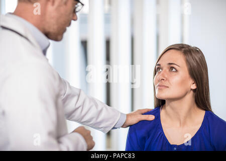 Arzt im Gespräch mit Patienten in der medizinischen Praxis Stockfoto