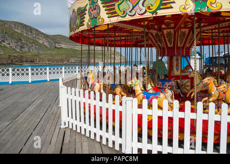 Bunte alte Karussell am Ed der Pier in Llandudno, North Wales, UK. Stockfoto