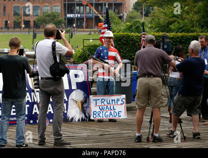 Ein Anhänger der republikanischen Präsidentschaftskandidaten Donald Trump stellt mit einem Gewehr beim Warten auf eine pro-Trumpf-Rally in der Nähe der Republican National Convention in Cleveland, Ohio, 18. Juli 2016 zu beginnen. Stockfoto