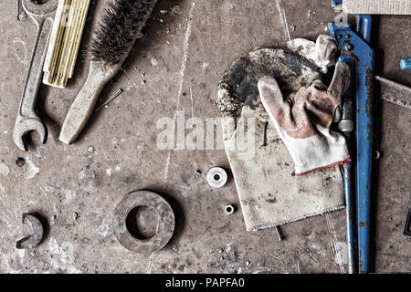 Nicht abgerechnete Workshop mit Tools. auf dem schmutzigen Tisch aus Stein verstreuten Tools Stockfoto