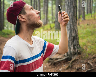 Junge Bartgeier hipster Blogger Live Stream im sozialen Netz Wandern im Wald Stockfoto