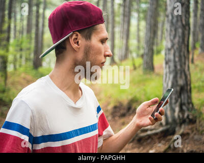 Junge Bartgeier hipster Blogger Live Stream im sozialen Netz Wandern im Wald Stockfoto