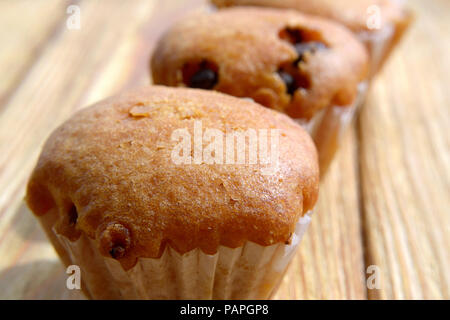 Muffins in einer Reihe auf einem Holz- Hintergrund Stockfoto