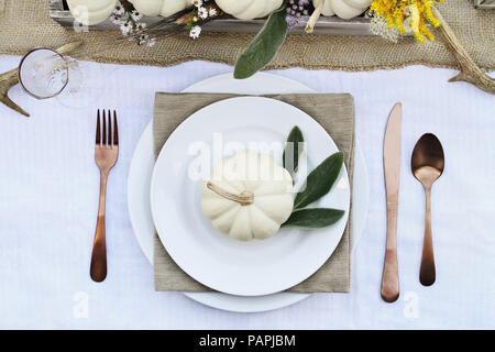 Vorbehalten Thanksgiving oder Halloween Ort Einstellung an einem Bauernhaus Tabelle mit mini white Pumpkins einstellen, bei dem Lamm Ohren verlässt, Geweih und Wildblumen f Stockfoto