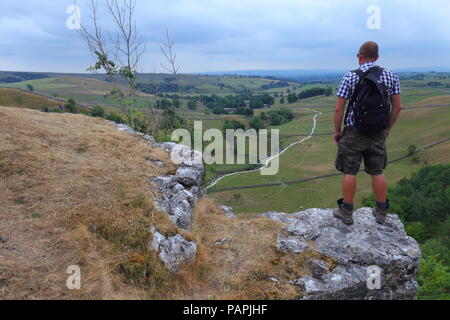 Ein Tourist findet in der schönen Landschaft der Yorkshire Dales von Malham Cove Stockfoto