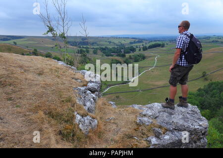 Ein Tourist findet in der schönen Landschaft der Yorkshire Dales von Malham Cove Stockfoto