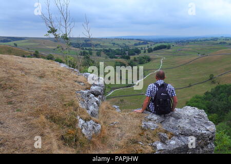 Ein Tourist findet in der schönen Landschaft der Yorkshire Dales von Malham Cove Stockfoto