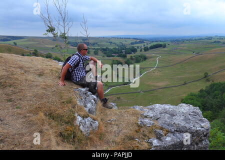 Ein Tourist findet in der schönen Landschaft der Yorkshire Dales von Malham Cove Stockfoto