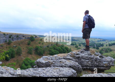 Ein Tourist findet in der schönen Landschaft der Yorkshire Dales von Malham Cove Stockfoto