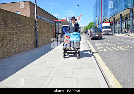 Orthodoxe/Chassidischen jüdischen Mann treibt ein doppeltes Kinderwagen, London, England, UK. Stockfoto