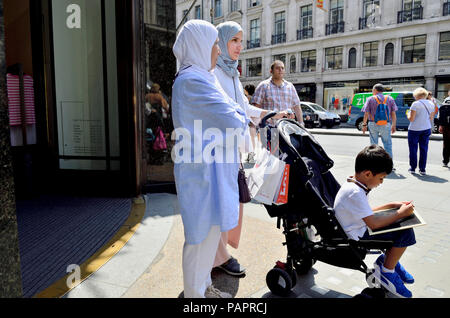 Zwei muslimische Frauen mit einem kleinen Jungen im Kinderwagen, der Regent Street, London, England, UK. Stockfoto