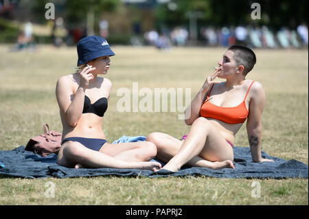 Frauen Sonnen im Green Park in London, als das heiße Wetter im ganzen Land geht weiter. Stockfoto