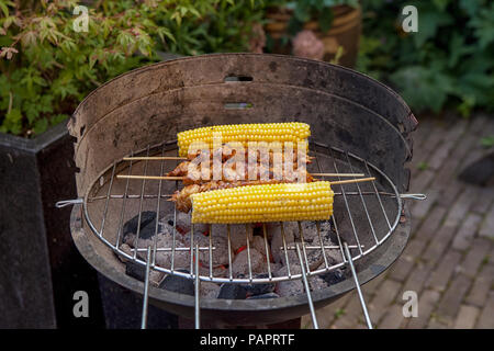 Barbecue im Garten mit Mais und Satay Stockfoto