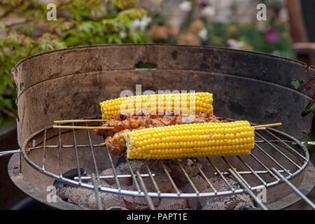 Nahaufnahme von gegrillten Satay und Maiskolben am Grill im Garten Stockfoto