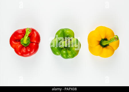 Blick von oben auf die drei frische helle Paprika auf weißem Hintergrund. Von oben von grünen, gelben und roten Paprika Gemüse Schuß Stockfoto