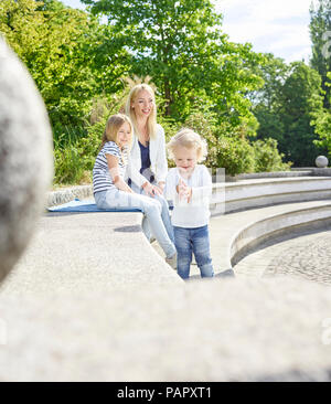 Mutter und ihre kleinen Töchter Zeit zusammen verbringen in einem Park Stockfoto