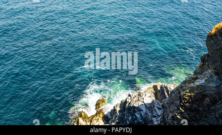 Bucht Godrevy, Cornwall, schöne, bunte, Aqua Ocean Wellen auf die Felsen. Stockfoto