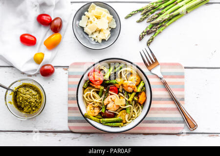 Spaghetti mit Garnelen, grüner Spargel, Tomaten, Pesto und Parmesan Stockfoto