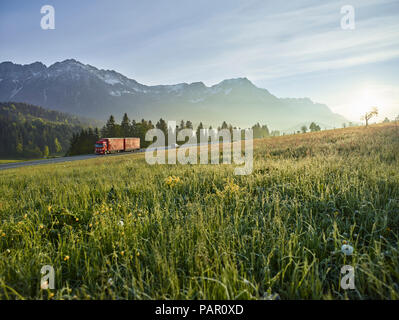 Österreich, Tirol, Lkw auf Landstraße im Morgenlicht Stockfoto