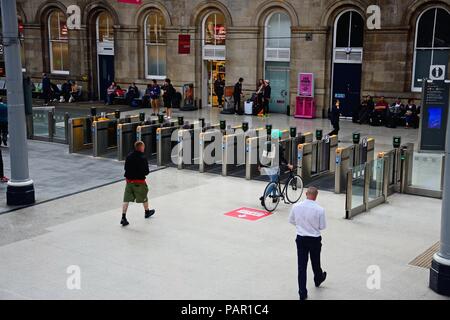 Leute, die das Ticket Barrieren innerhalb Newcastle Hauptbahnhof mit Passagiere warten auf der Rückseite, Newcastle upon Tyne, Tyne und Wear, Ger Stockfoto