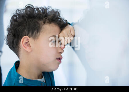 Betont Schüler gegen Whiteboard schiefen in der Klasse Stockfoto