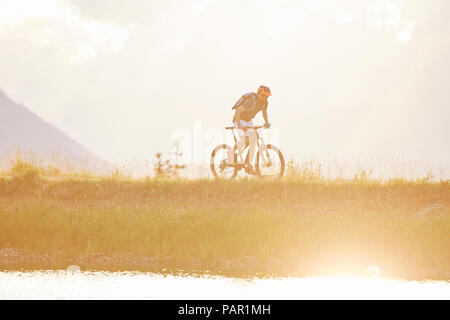 Österreich, Tirol, Mountainbiker im Abendlicht Stockfoto