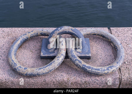 Zwei verkaufen verschlissenen Ringen aus Stahl verankert werden zu einem Kai von Copenhaven, Dänemark, bereit für Ihre nächste Schiff bis zu Moor Stockfoto