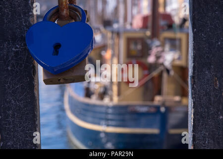 Ein Detail shot Übersicht Liebhaber Vorhängeschlösser sind zusammen auf dem Metall Geländer einer Brücke in Nyhavn in Kopenhagen, Dänemark mit einem Segel schiff verbunden Stockfoto