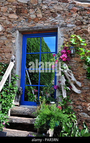 Schrullige verspiegelten Tür an der Oberseite des hölzernen Stufen in einem wunderschönen Innenhof mit Garten im Süden von Frankreich. Eigenschaft freigegeben Stockfoto