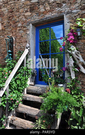 Schrullige verspiegelten Tür an der Oberseite des hölzernen Stufen in einem wunderschönen Innenhof mit Garten im Süden von Frankreich. Eigenschaft freigegeben Stockfoto