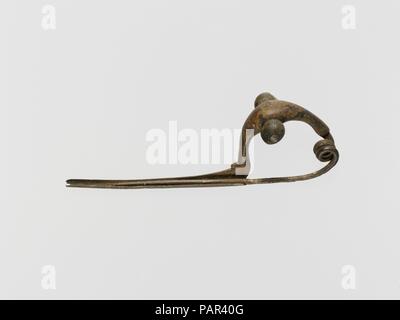 Bronze bug-Fibel (Safety Pin). Kultur: Etrusker. Abmessungen: Andere: 4 3/8 in. (11,1 cm). Termin: Anfang 7. Der Bogen ist hohl. Auf der Oberseite ist eine gelochte Kreis. Der Kopf ist durch eine Spirale von zwei Umdrehungen gebildet. Museum: Metropolitan Museum of Art, New York, USA. Stockfoto