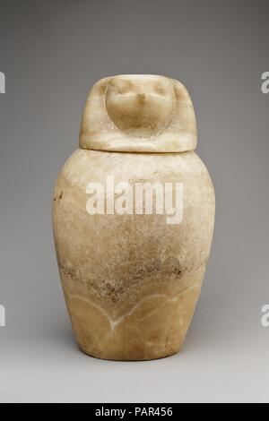 Canopic jar mit einem Falken - vorangegangen Deckel (qebehsenuef). Abmessungen: Behälter und Deckel: H 42 cm (16 9/16 Zoll); größte Diam. 25 cm (9 13/16 in.) Jar: H 31,1 cm (12 1/4 in.); d. 25,5 cm (10 1/16 in.); Dam. der Öffnung 14 cm (5 1/2 in.) Durchmesser der Basis 15,2 cm (6 in.); Circ. 77,7 cm (30 9/16 in.) Deckel: H 12,3 cm (4 13/16 in.); w. 17,6 cm (6 15/16 in.); d. 17,8 cm (7 in.); Durchm. Der Fuß 13,6 cm (5 3/8 in.). Dynastie: Dynasty 26. Datum: 664-525 v. Chr.. Kanopen wurden der einbalsamierte Eingeweide aus dem Körper in den Prozess der Mumifizierung entfernt zu enthalten. Die Organe wurden unter dem Schutz der F platziert Stockfoto