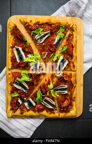 Pizza Marinara garniert mit Sardellen und Petersilie Stockfoto