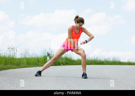 Joggen Frau tun Stretching Übungen auf der Straße Stockfoto