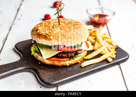 Hausgemachte Hamburger mit Käse, Pommes frites, Ketchup und Tomatenmark Stockfoto