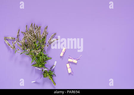 Schöne erstaunliche mint Blumenstrauß mit violetten Band auf Violett Oberfläche. Ansicht von oben, kopieren. Stockfoto
