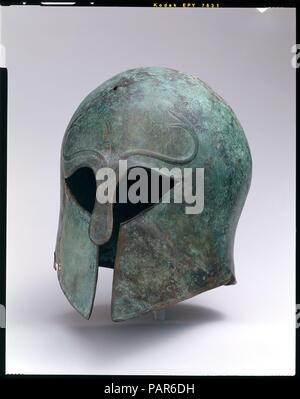 Bronze Helm der Korinther Art. Kultur: Griechisch. Abmessungen: Insgesamt: 8 7/8 x 7 1/4 in. (22,6 x 18,5 cm). Datum: Ca. 600-575 v. Chr.. Über Augen, Lotos und Palmetten durch heraldische Schlangen flankiert; unten auf jeder Seite, Palmette. Museum: Metropolitan Museum of Art, New York, USA. Stockfoto