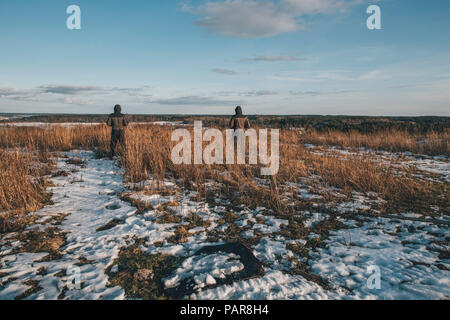 Schweden, Sodermanland, zwei Männer in abgelegenen Landschaft stehen im Winter Stockfoto