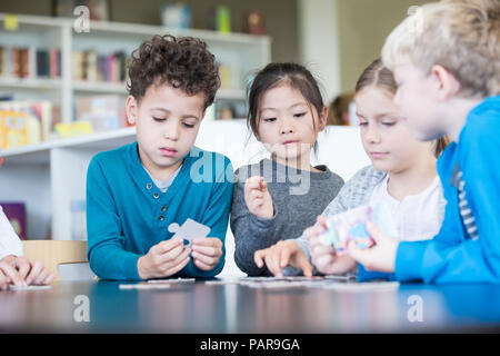 Schüler zusammen spielen Puzzle in der Schule Stockfoto