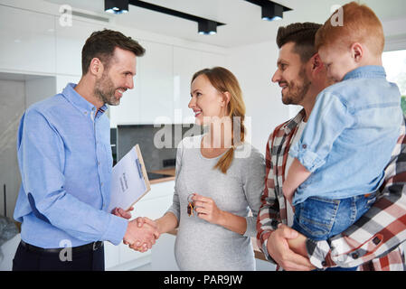 Familie und real estate agent Händeschütteln in neue Wohnung Stockfoto