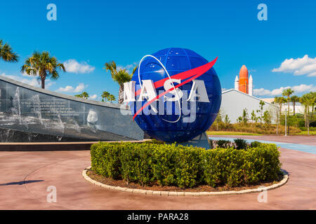 NASA-Logo auf Weltkugel im Kennedy Space Center Visitor Komplex in Cape Canaveral, Florida, USA. Auf der linken Seite ist ein Bild sichtbar von John F. Kennedy. Stockfoto