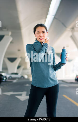 Runner Ausrottung der Schweiß nach dem Training auf dem Parkplatz vor Stockfoto