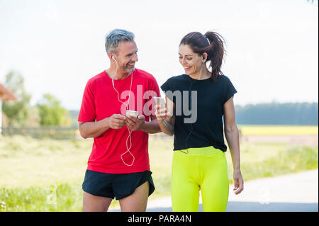 Paar mit Smartphones während des Trainings Stockfoto