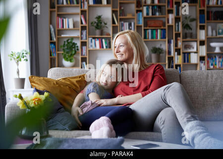 Mutter und Tochter kuscheln auf couch Stockfoto