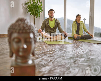 Paar Üben Yoga in einem Zimmer mit Panorama Fenster Stockfoto