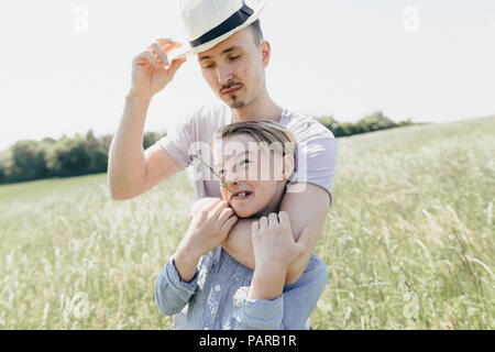 Junger Mann mit Hut und Junge auf einem Feld Stockfoto